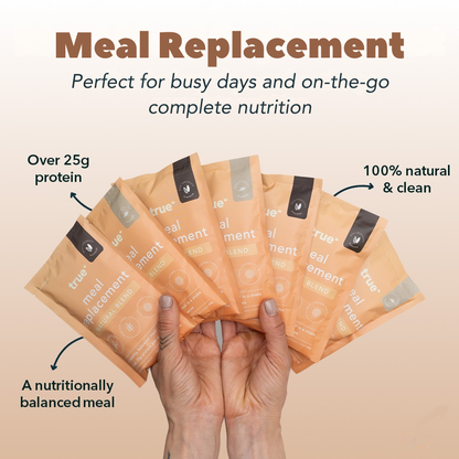 Image of six peach-coloured True Meal Replacement sachets fanned in hands, labeled "natural blend" and promoting "over 25g protein," "100% natural &amp; clean" and "a nutritionally balanced meal" — convenient on-the-go nutrition.
